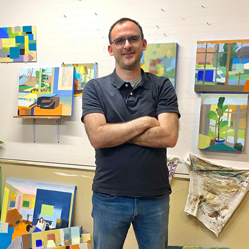 Portrait of artist Ben Frederick with his paintings