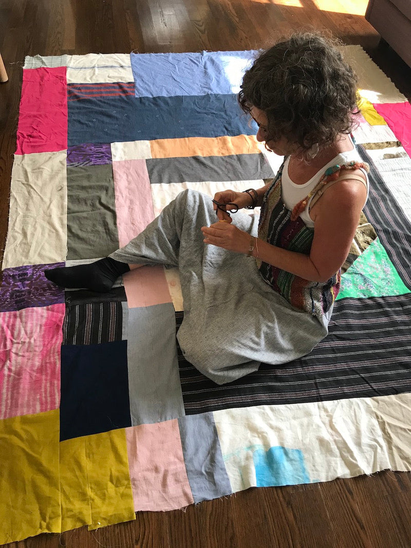 Portrait of Debby Weiss working on a quilt