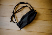 Black crossbody bag on a wooden surface
