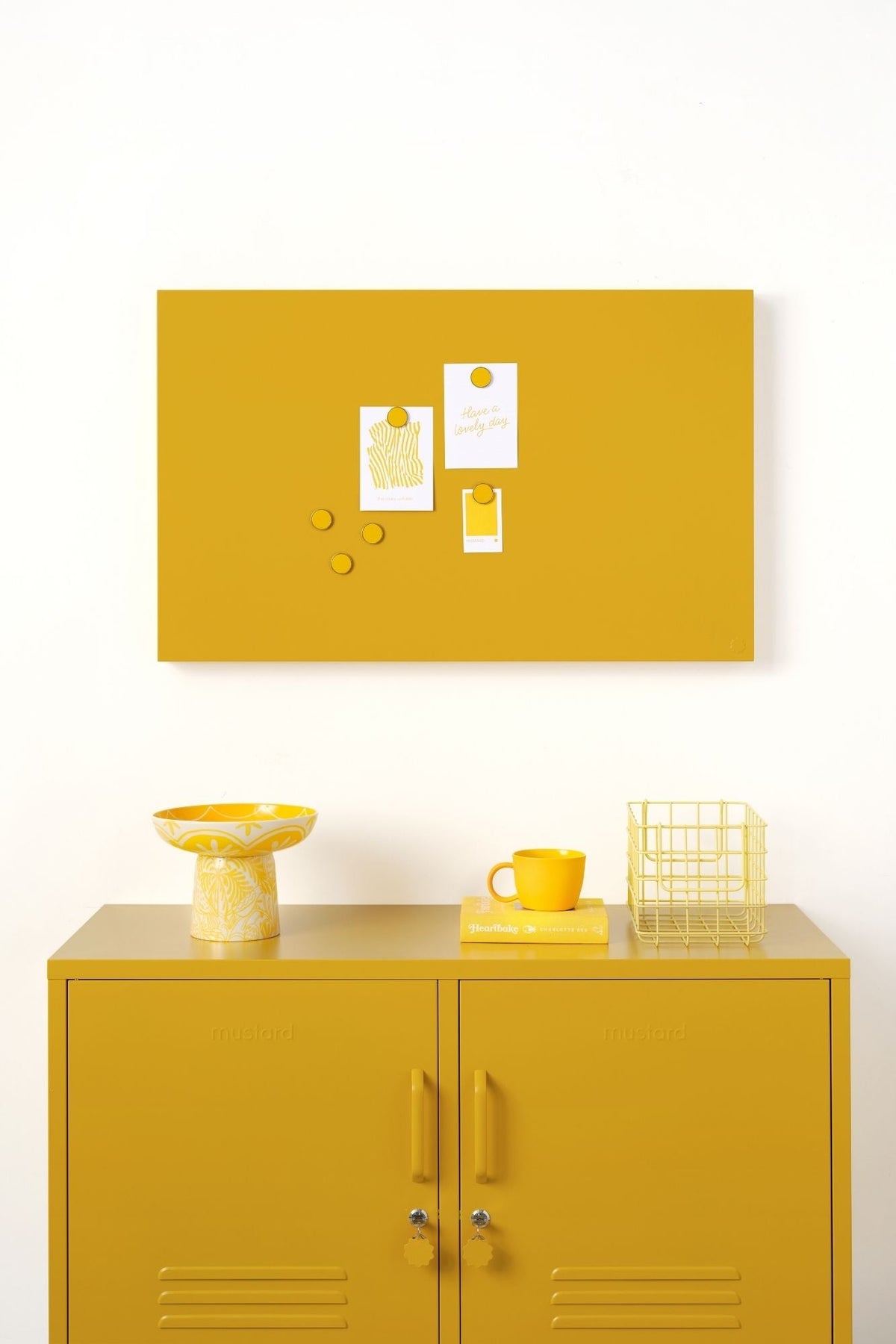 Yellow locker cabinet with a matching yellow magnetic board on a white wall.