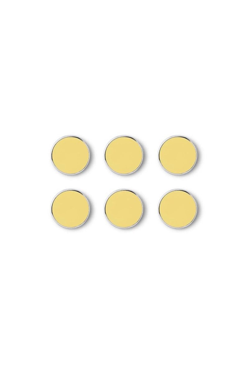 Six yellow circular magnets on a white background