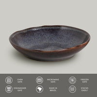 Ceramic pasta plate with speckled texture on a light gray background