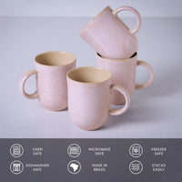 Set of pink ceramic mugs with handles on a light gray background