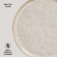 Close-up of a ceramic plate with reactive glaze texture on a light gray background