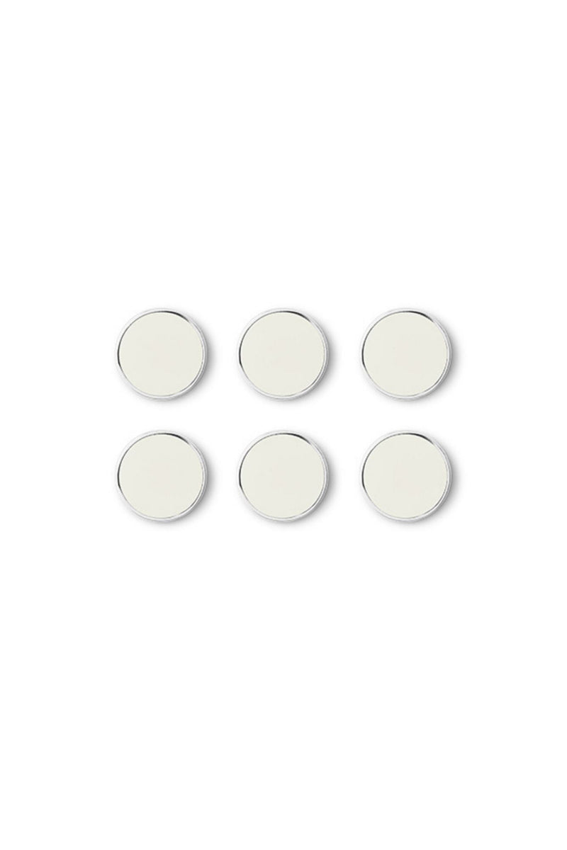 Set of six round white magnets with silver trim on a white background