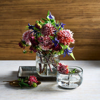 Bouquet of flowers in a glass vase on a wooden surface