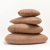 Stack of four brown cushions on a white background