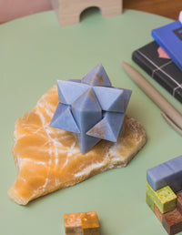 Geometric stone model on a rock with stationery items in the background