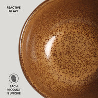 Brown ceramic plate with reactive glaze on a light gray background