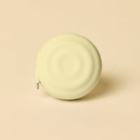 Round, light yellow charging product on a beige background