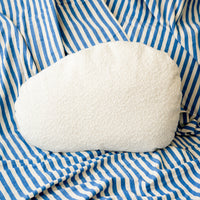 White pillow on a blue and white striped fabric background
