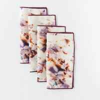 Set of four patterned cocktail napkins folded on a white background