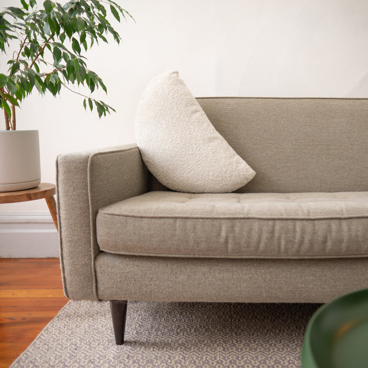 Beige sofa with a pillow in a living room setting
