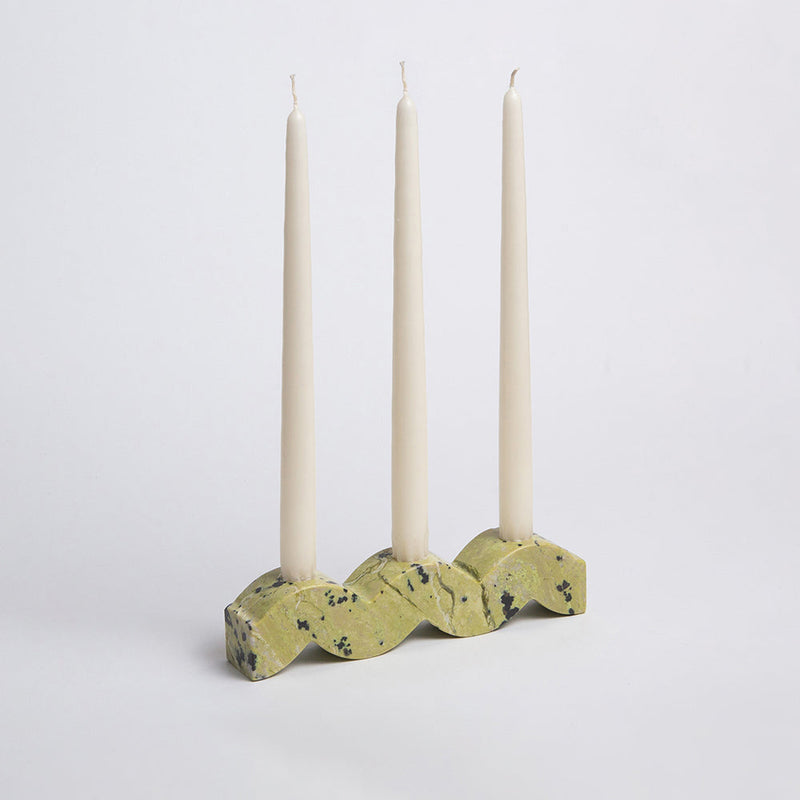 Wavy Stone Candle holder with three taper candles on a white background