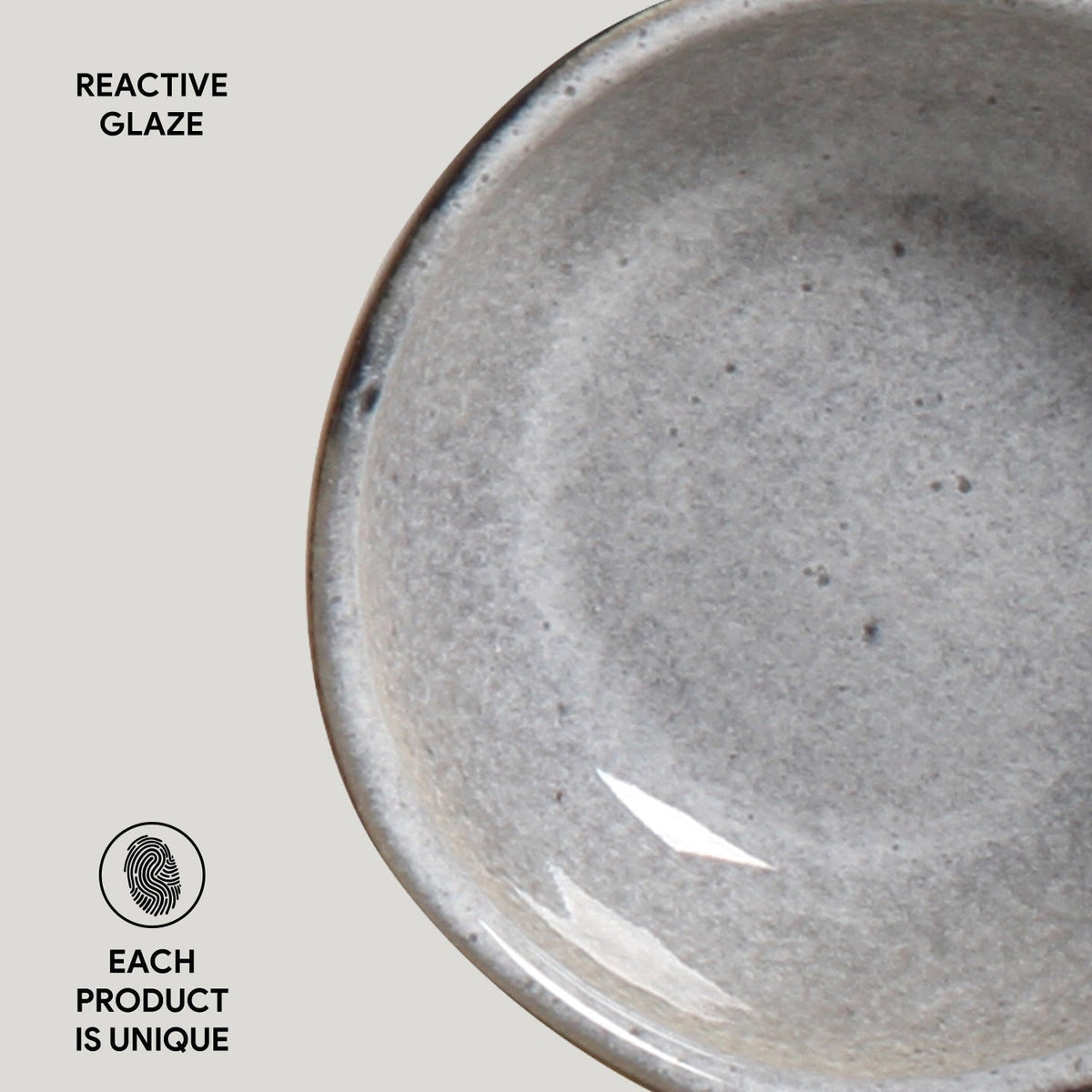 Close-up of a gray ceramic bowl with 'Reactive Glaze' text and 'Each Product is Unique' label.