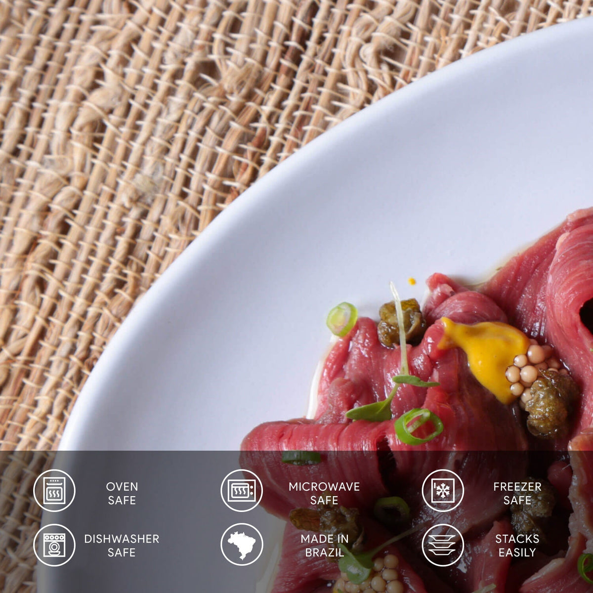 Plated dish of raw fish with garnishes on a woven mat background with safety and feature icons about the plate below