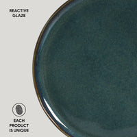 Teal ceramic plate with reactive glaze on a light gray background