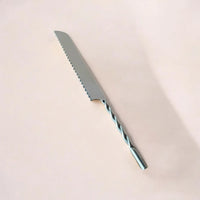 Bread knife with a twisted blade on a beige background