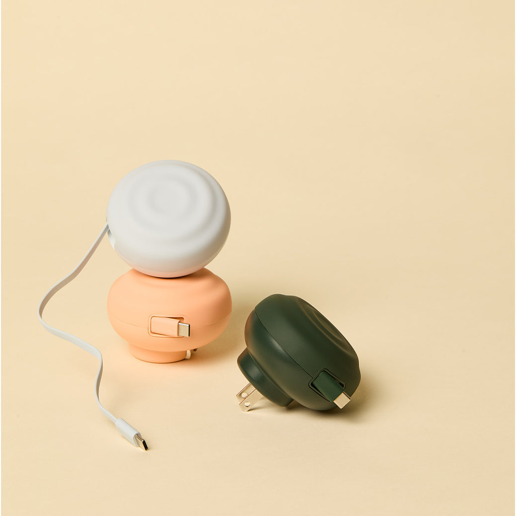 Three spherical charging cords on a beige background