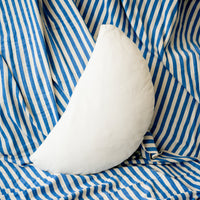 White half circle pillow on a blue and white striped fabric background