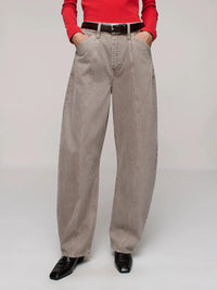 Person wearing beige jeans with a red top on a plain background