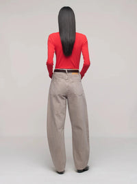 Person wearing a red top and beige pants on a plain background