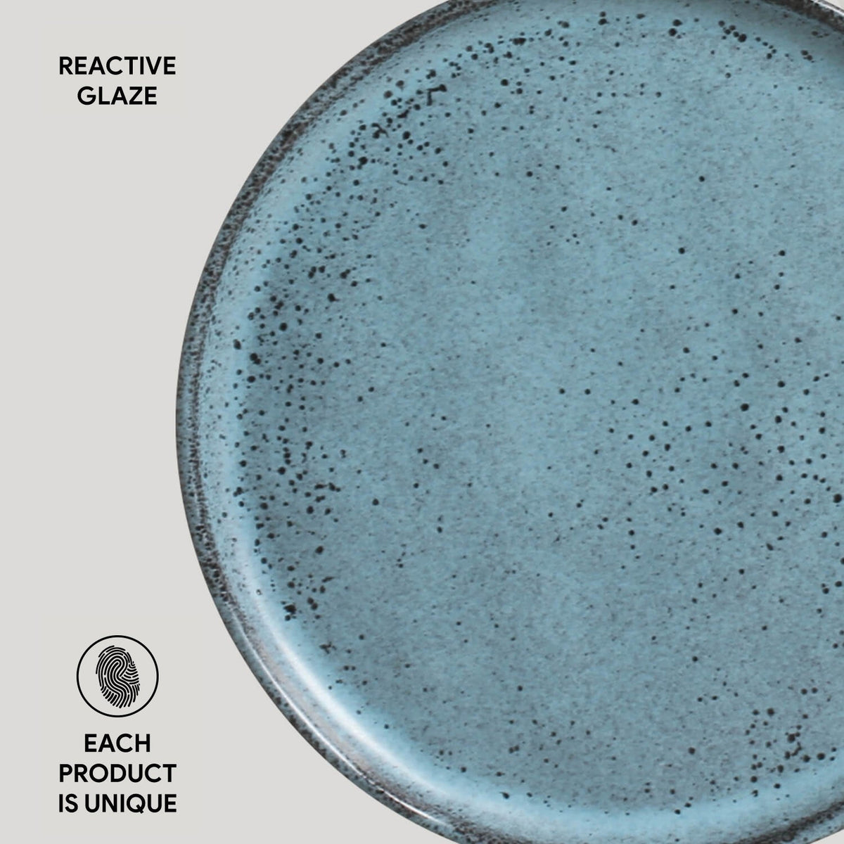 Blue ceramic plate with speckled texture on a light gray background