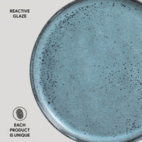 Blue ceramic plate with speckled texture on a light gray background