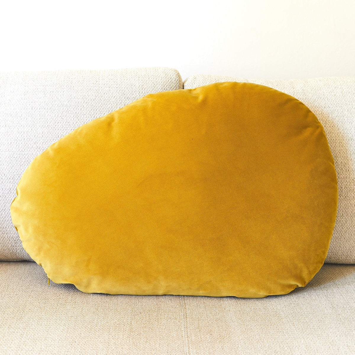 Mustard yellow pillow on a beige sofa