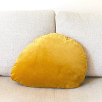 Yellow velvet pillow on a beige sofa