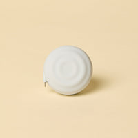 White spherical object with a charging cord on a beige background