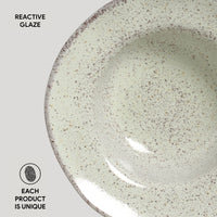 Ceramic bowl with reactive glaze on a light gray background