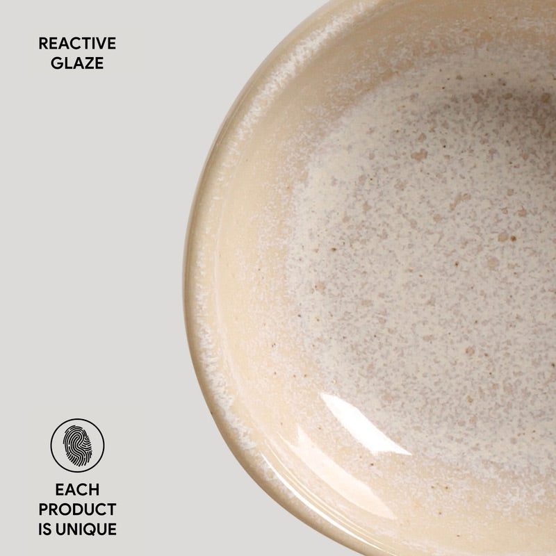 Close-up of a ceramic bowl with reactive glaze on a light gray background