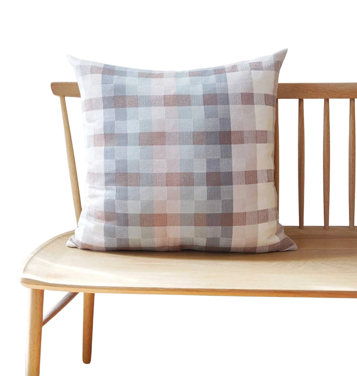 Plaid pillow on a wooden bench with a white background