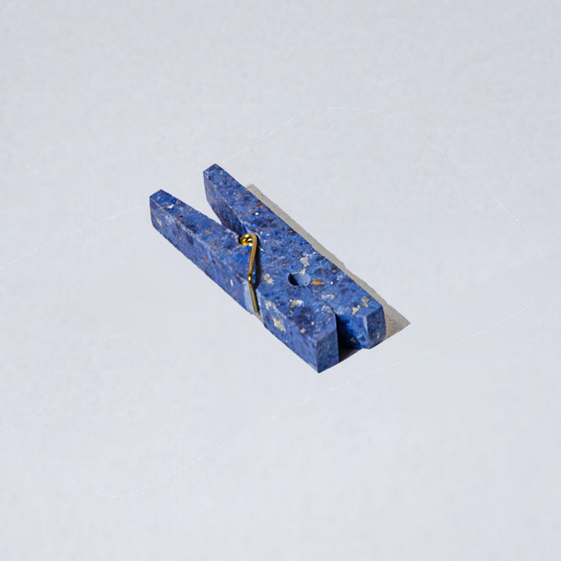 Blue stone clothespin clip on a light gray background