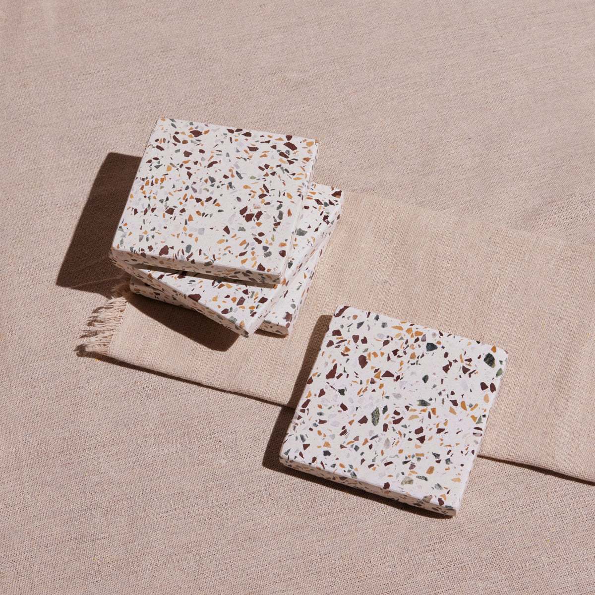 Terrazzo patterned coasters on a beige surface