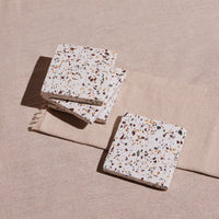 Terrazzo patterned coasters on a beige surface