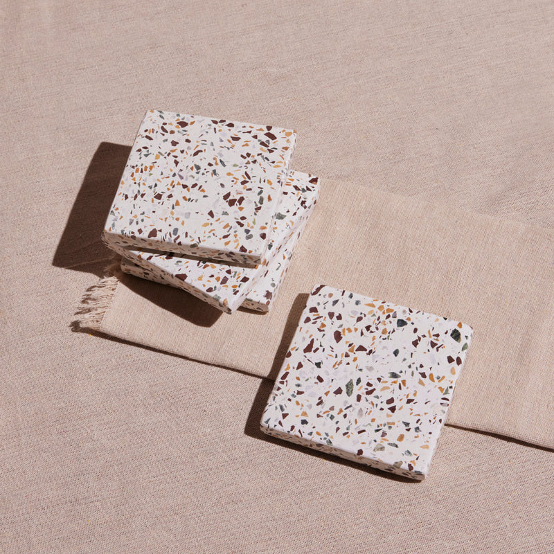 Terrazzo patterned coasters on a beige surface
