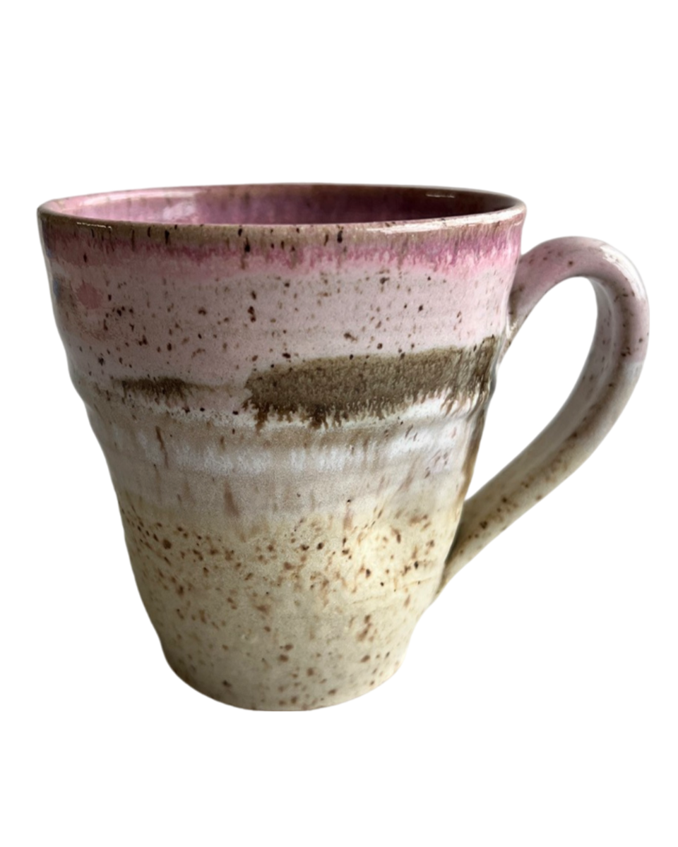 Ceramic mug with light and dark neutral and pink glaze details on a white background