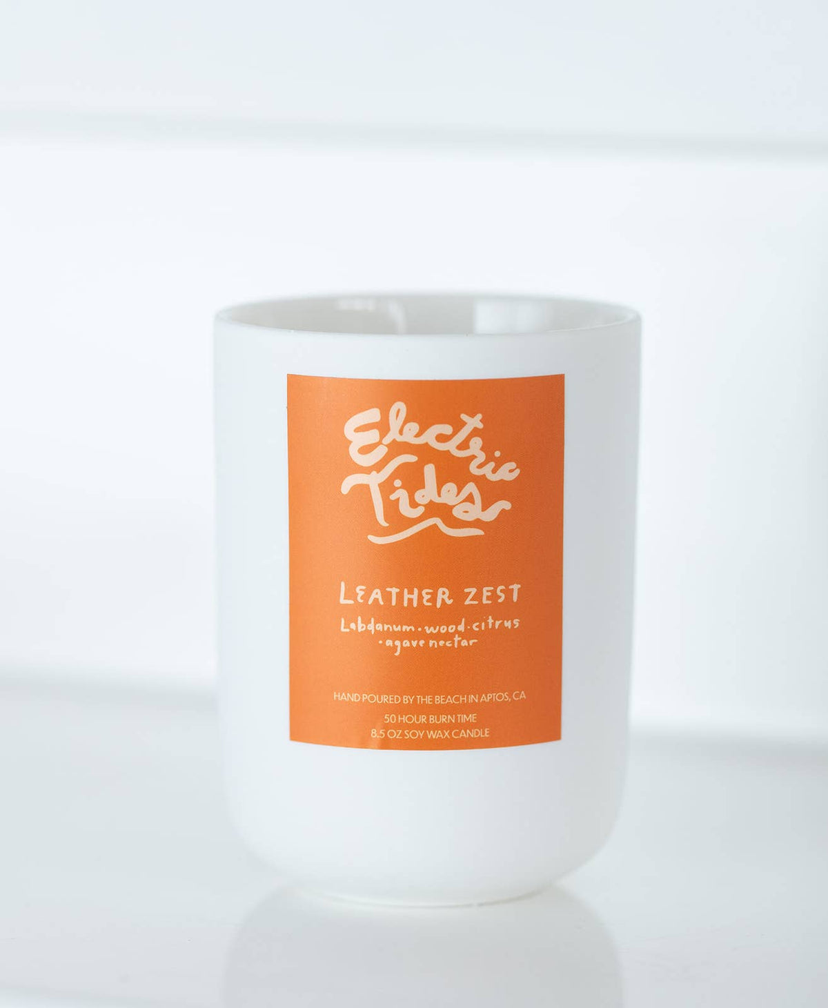 Candle with an orange label on a white background