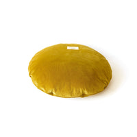 Round mustard yellow cushion on a white background