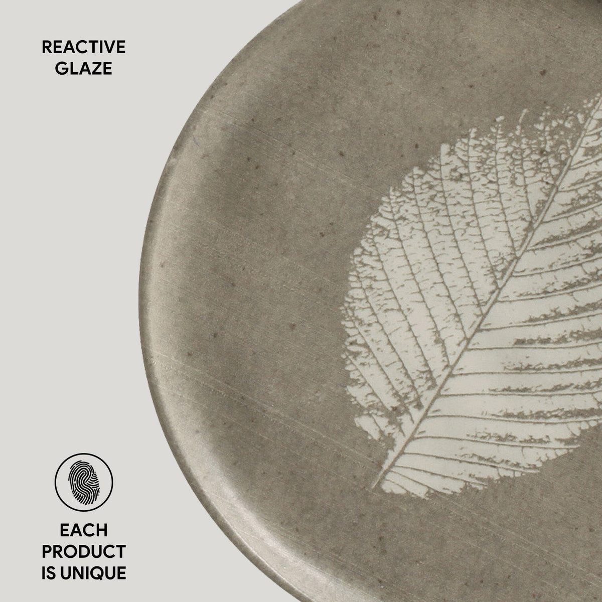 Ceramic plate with a leaf design and 'Reactive Glaze' text on a light gray background