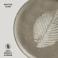 Ceramic plate with a leaf design and 'Reactive Glaze' text on a light gray background