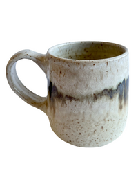 Ceramic mug with light and dark neutral glaze details on a white background