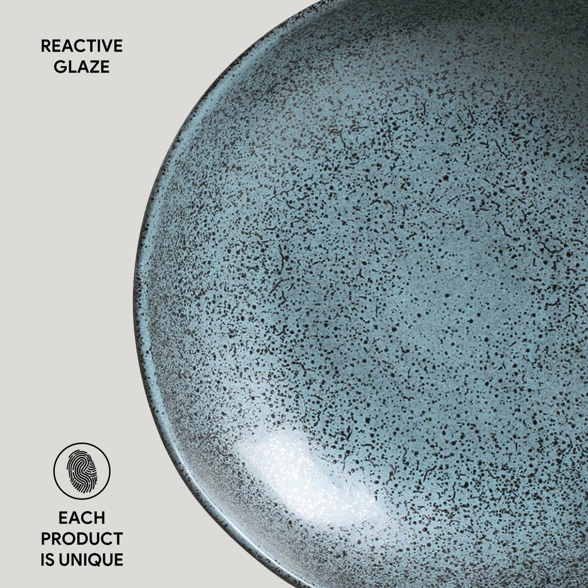 Close-up of a ceramic plate with reactive glaze texture on a light gray background.