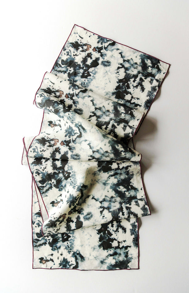 Folded table runner with black and white pattern on a white background