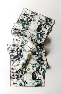 Folded table runner with black and white pattern on a white background