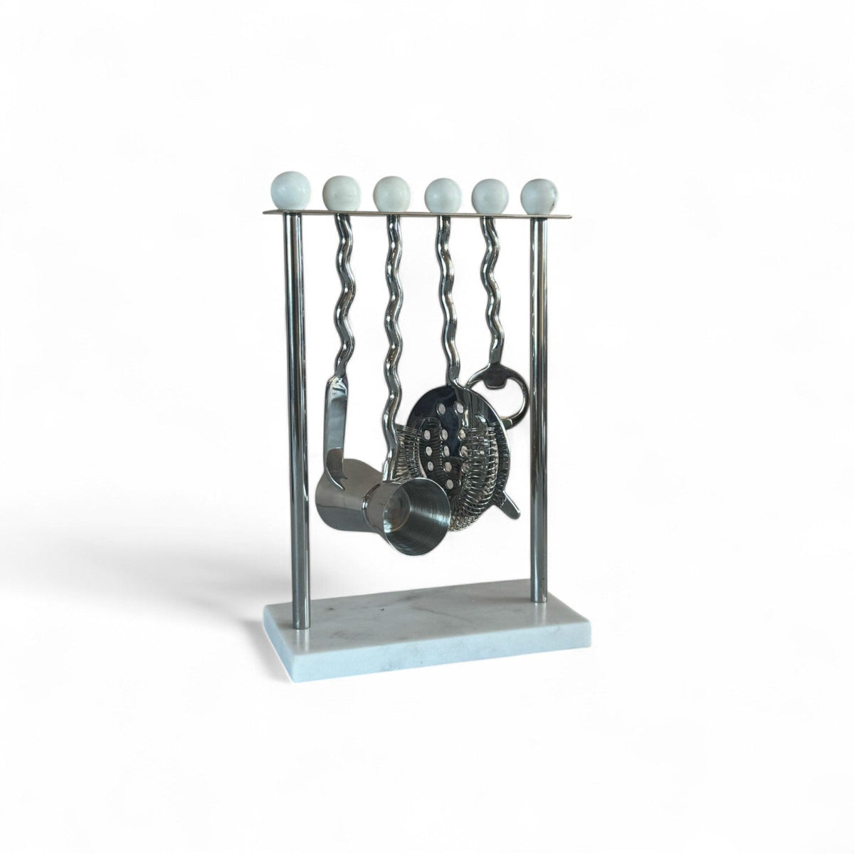 Metallic barware set on a stand with marble base against a white background