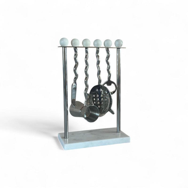 Metallic barware set on a stand with marble base against a white background