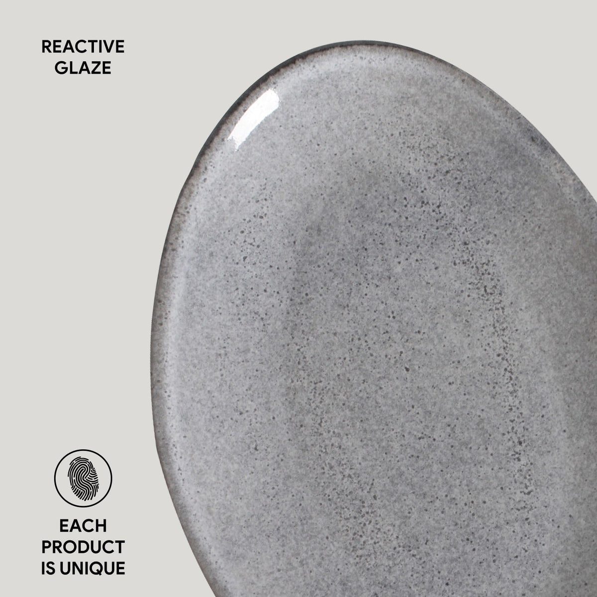 Close-up of a gray ceramic plate with 'Reactive Glaze' text and 'Each Product is Unique' label.